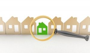Magnifying glass selects or inspects eco-home in row of houses